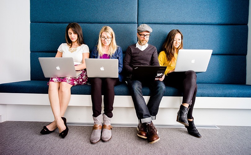 Four people sitting on a couch together using LinkedIn's referral program